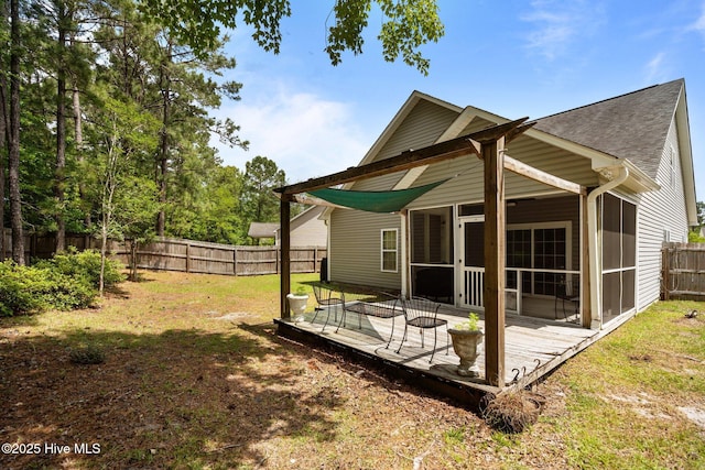 rear view of property with a sunroom, a wooden deck, and a shingled roof