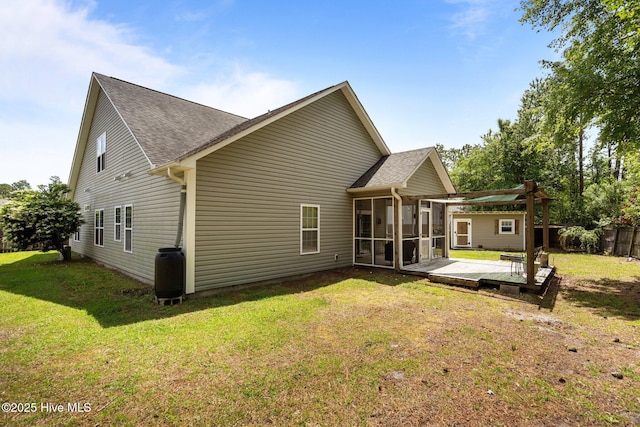 back of house featuring a sunroom, a shingled roof, and a deck
