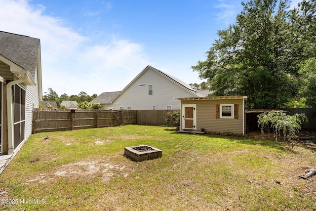 view of yard featuring a fire pit and an outdoor structure