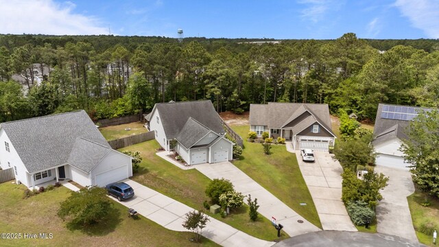 aerial view of property and surrounding area featuring a heavily wooded area