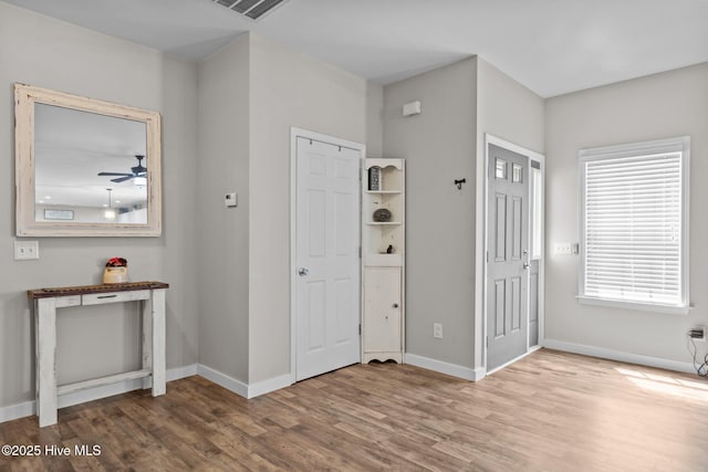 foyer entrance with wood finished floors, baseboards, and ceiling fan