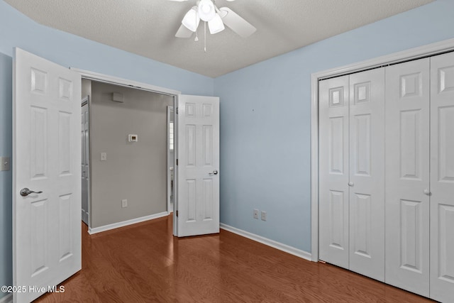 unfurnished bedroom with baseboards, ceiling fan, a closet, and wood finished floors