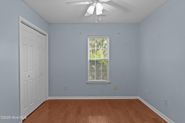 808 Tanlaw Ct, Wilmington, NC 28412 - unfurnished bedroom with wood finished floors, a closet, ceiling fan, and a textured ceiling