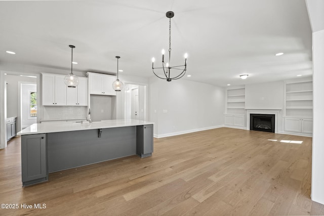 231 Dona Dr, Carthage, NC 28327 - kitchen featuring white cabinetry, light countertops, light wood-type flooring, a sink, and a chandelier