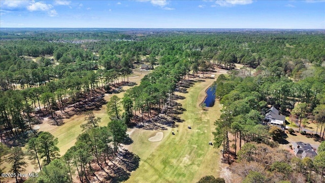 aerial view featuring golf course view and a wooded view