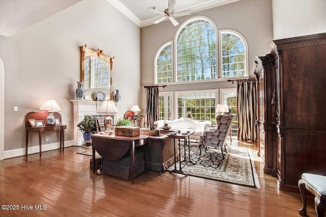 sitting room with ceiling fan, ornamental molding, and wood finished floors