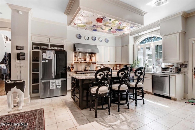 kitchen with crown molding, light tile patterned flooring, tasteful backsplash, and stainless steel appliances