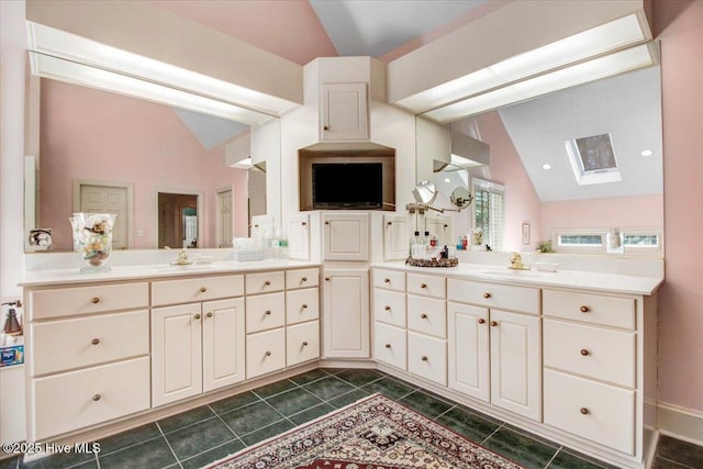 full bath featuring tile patterned floors, a sink, and vaulted ceiling with skylight