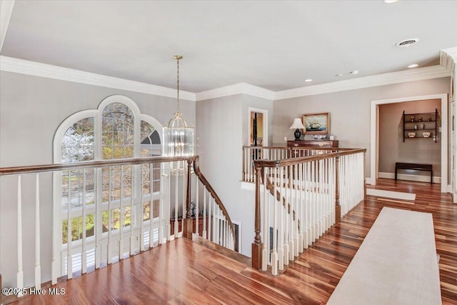 hall featuring crown molding, a notable chandelier, an upstairs landing, and visible vents