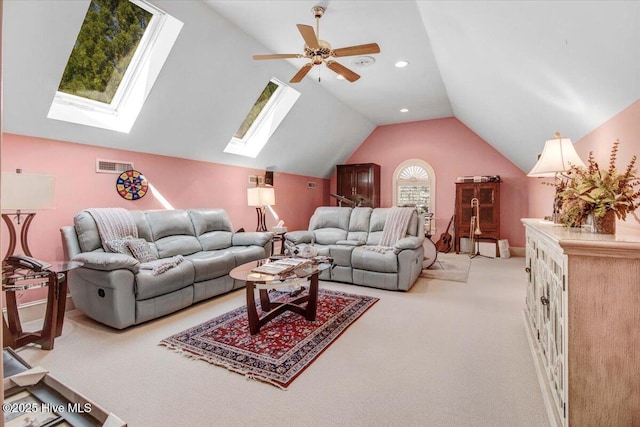 living area featuring visible vents, lofted ceiling with skylight, recessed lighting, light colored carpet, and a ceiling fan