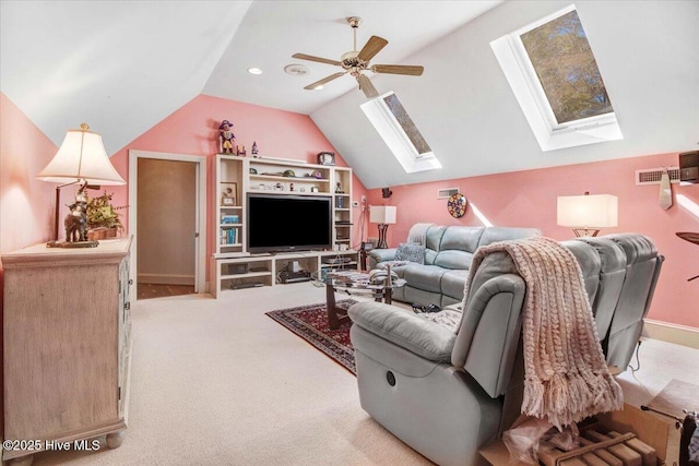 living area with visible vents, ceiling fan, light colored carpet, and lofted ceiling with skylight