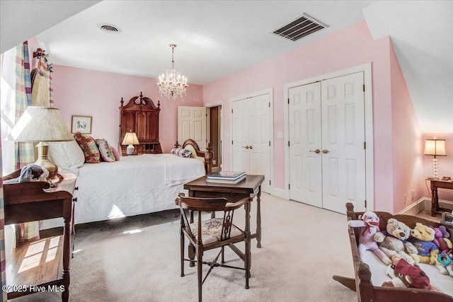 bedroom featuring two closets, light colored carpet, visible vents, and an inviting chandelier