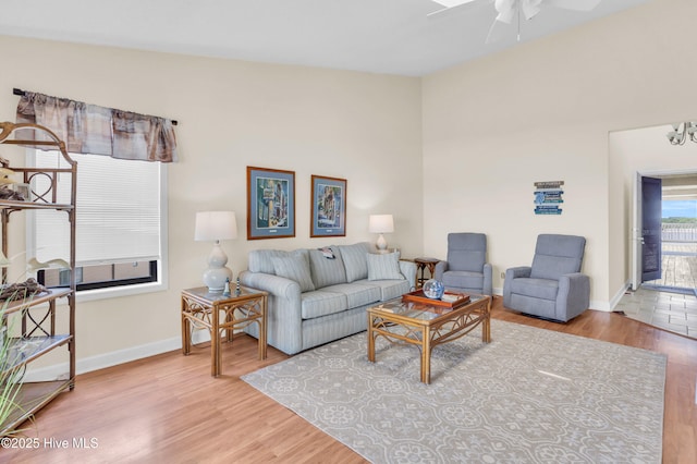 living room with baseboards, a ceiling fan, and wood finished floors