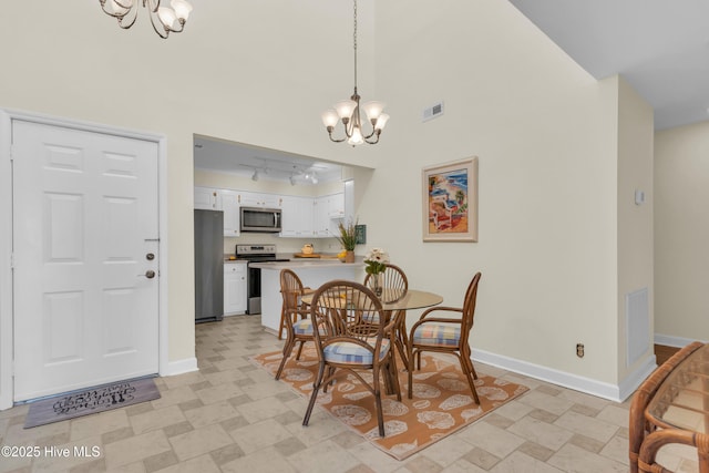 dining area featuring track lighting, baseboards, visible vents, and a chandelier