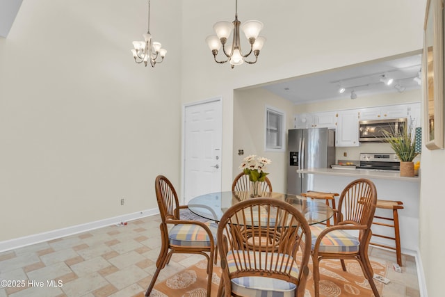dining area featuring baseboards and a chandelier