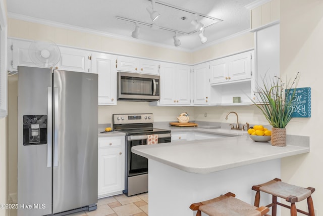 1896 New River Inlet Rd Unit 1402, North Topsail Beach, NC 28460 - kitchen with stainless steel appliances, a peninsula, light countertops, white cabinets, and a breakfast bar area