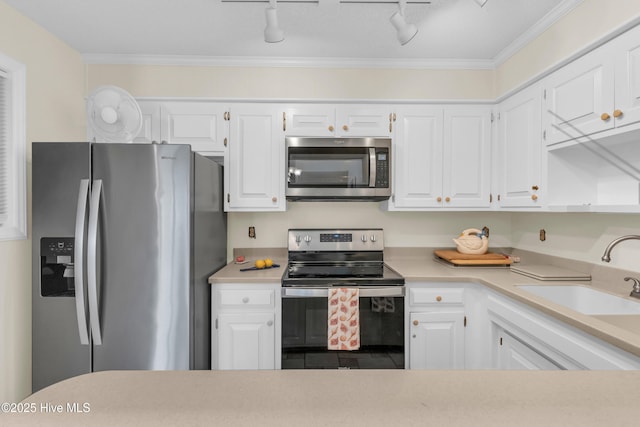 kitchen with a sink, appliances with stainless steel finishes, white cabinets, and light countertops