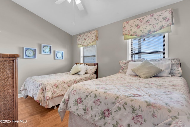 bedroom featuring baseboards, a ceiling fan, light wood-style flooring, and vaulted ceiling