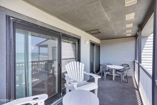 balcony with outdoor dining area and visible vents