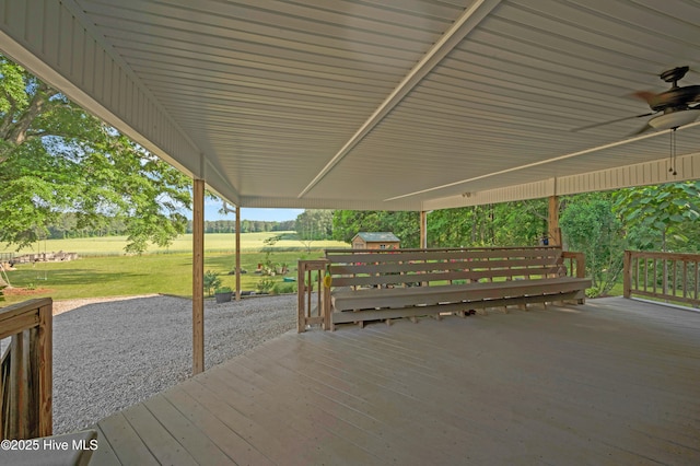 deck featuring a ceiling fan, a yard, and area for grilling