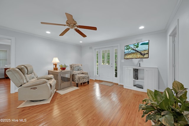 living room featuring crown molding, a ceiling fan, light wood-style floors, and recessed lighting