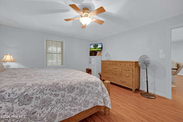 bedroom featuring a ceiling fan, baseboards, ornamental molding, and light wood-type flooring