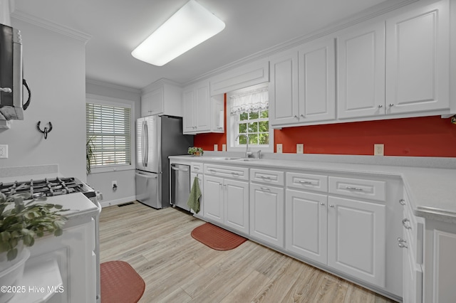 kitchen with a sink, white cabinetry, and stainless steel appliances