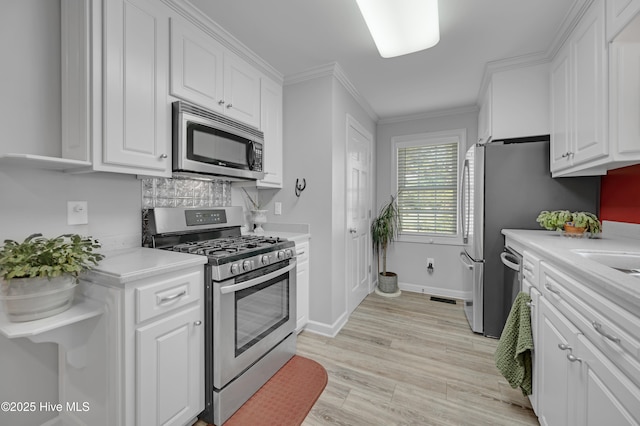 kitchen featuring light countertops, white cabinetry, appliances with stainless steel finishes, and decorative backsplash