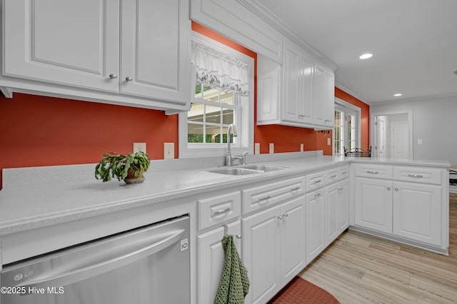 kitchen with white cabinets, a sink, dishwasher, light countertops, and recessed lighting
