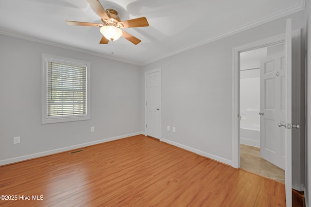 unfurnished bedroom with visible vents, light wood-style flooring, crown molding, and baseboards