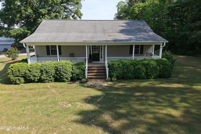 view of front facade with a front lawn, roof with shingles, and covered porch