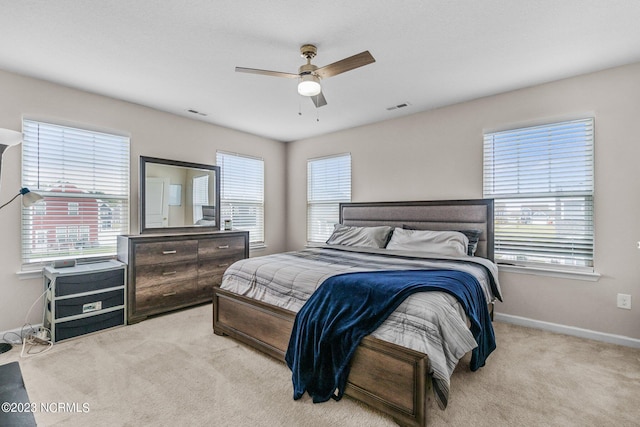 carpeted bedroom featuring baseboards, multiple windows, and visible vents