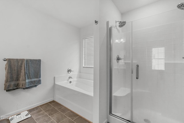full bath featuring a stall shower, a wealth of natural light, a garden tub, and baseboards