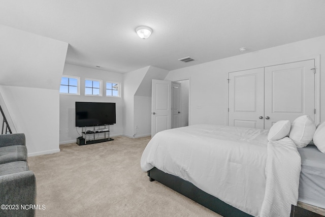 bedroom featuring light carpet, baseboards, a closet, and visible vents