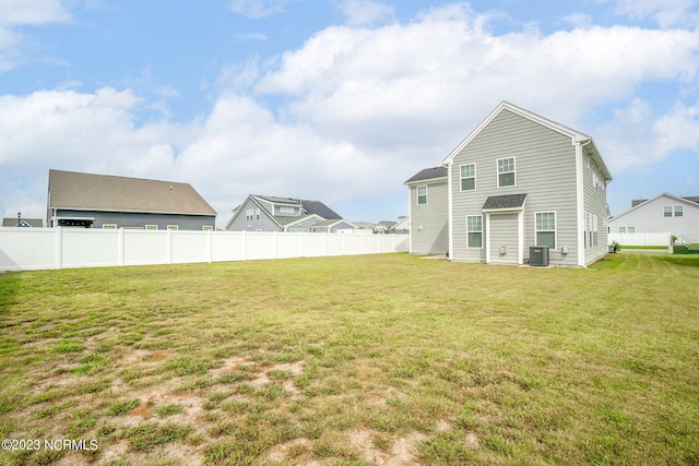 back of property with cooling unit, fence, and a lawn
