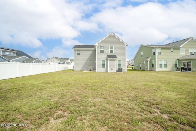 back of property featuring a yard, fence, central air condition unit, and a residential view