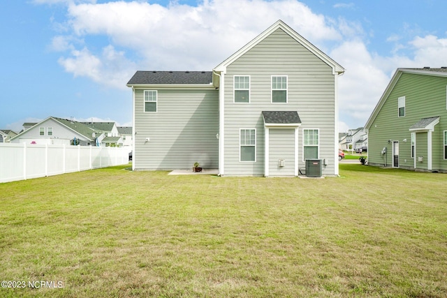 back of house featuring fence, a shingled roof, cooling unit, and a lawn