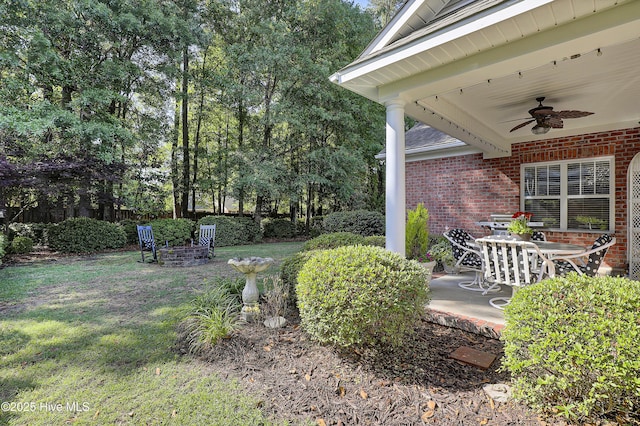 8130 Porters Crossing Way, Wilmington, NC 28411 - view of green lawn featuring a ceiling fan, a patio, and view of wooded area