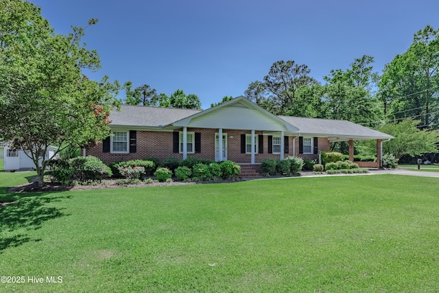 single story home featuring covered porch, driveway, a front yard, brick siding, and an attached carport
