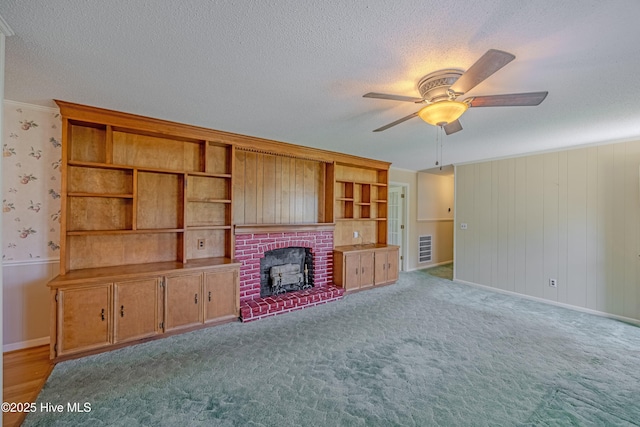 unfurnished living room with crown molding, baseboards, ceiling fan, and a textured ceiling