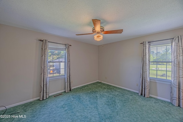 carpeted empty room featuring baseboards, a ceiling fan, and a textured ceiling