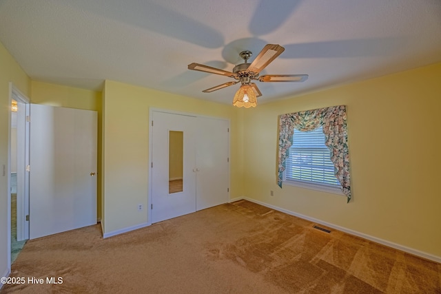 unfurnished bedroom featuring baseboards, carpet, and visible vents