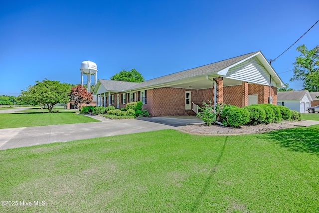 ranch-style home with aphalt driveway, brick siding, and a front yard