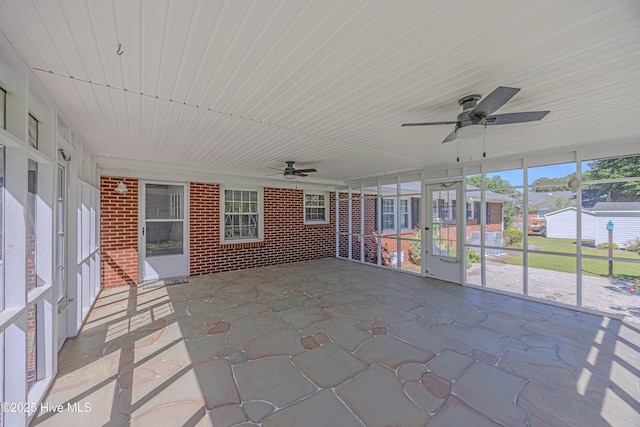 unfurnished sunroom with ceiling fan