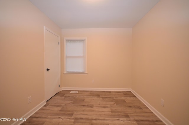 empty room with baseboards, visible vents, and light wood-style flooring