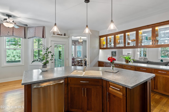kitchen with a sink, stainless steel dishwasher, ceiling fan, light wood-type flooring, and pendant lighting