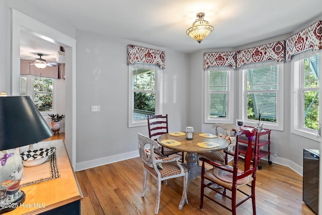 dining area with light wood-type flooring, baseboards, and a ceiling fan