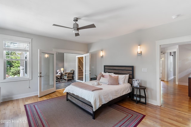 bedroom featuring light wood-style flooring, baseboards, a ceiling fan, and access to outside