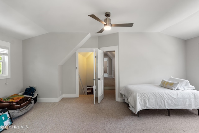 carpeted bedroom featuring lofted ceiling, a ceiling fan, and baseboards