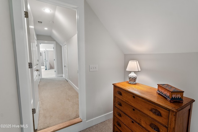 hall featuring lofted ceiling, light colored carpet, baseboards, and recessed lighting